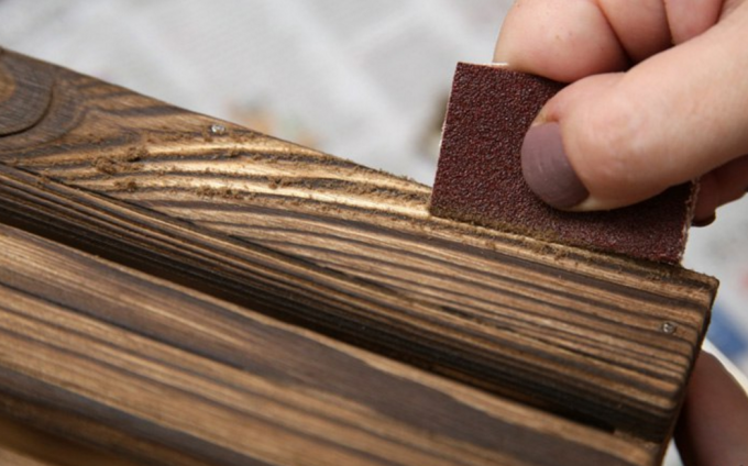 sandpaper के साथ ब्रश लकड़ी। 