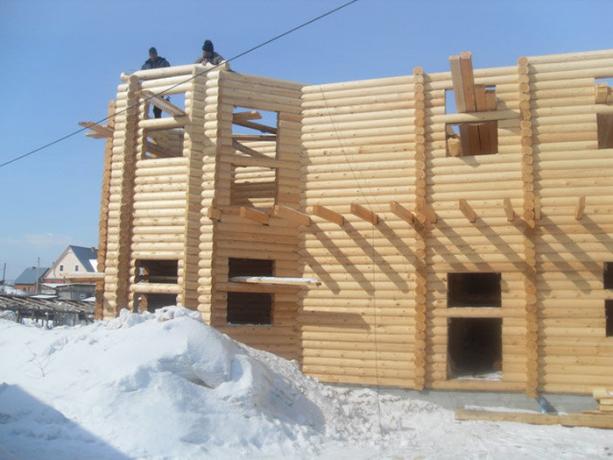सर्दियों में लकड़ी का एक घर का निर्माण।